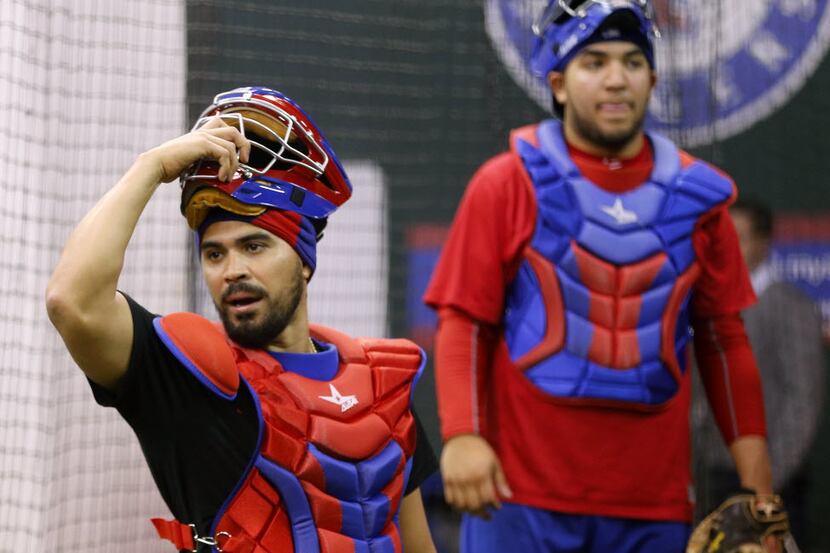 Catcher Robinson Chirinos (left) and others caught pitches in their indoor workout area of...