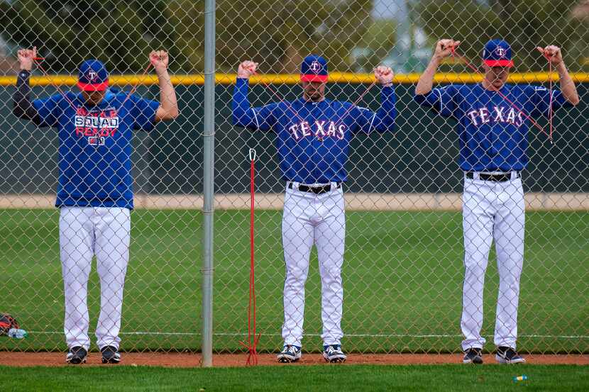From left: Texas Rangers pitchers Ariel Jurado, Taylor Guerrieri and Luke Farrell stretch...