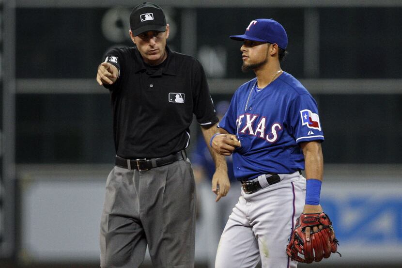 May 12, 2014; Houston, TX, USA; Second base umpire Bill Welke (left) awards a base to the...