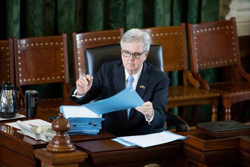 Lt. Gov. Dan Patrick signs a stack of bills while listening to questions by Senate Democrats...