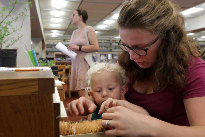 Roland Upchurch, 2,  and Jeneva Upchurch browse the new seed library program at the Dallas...