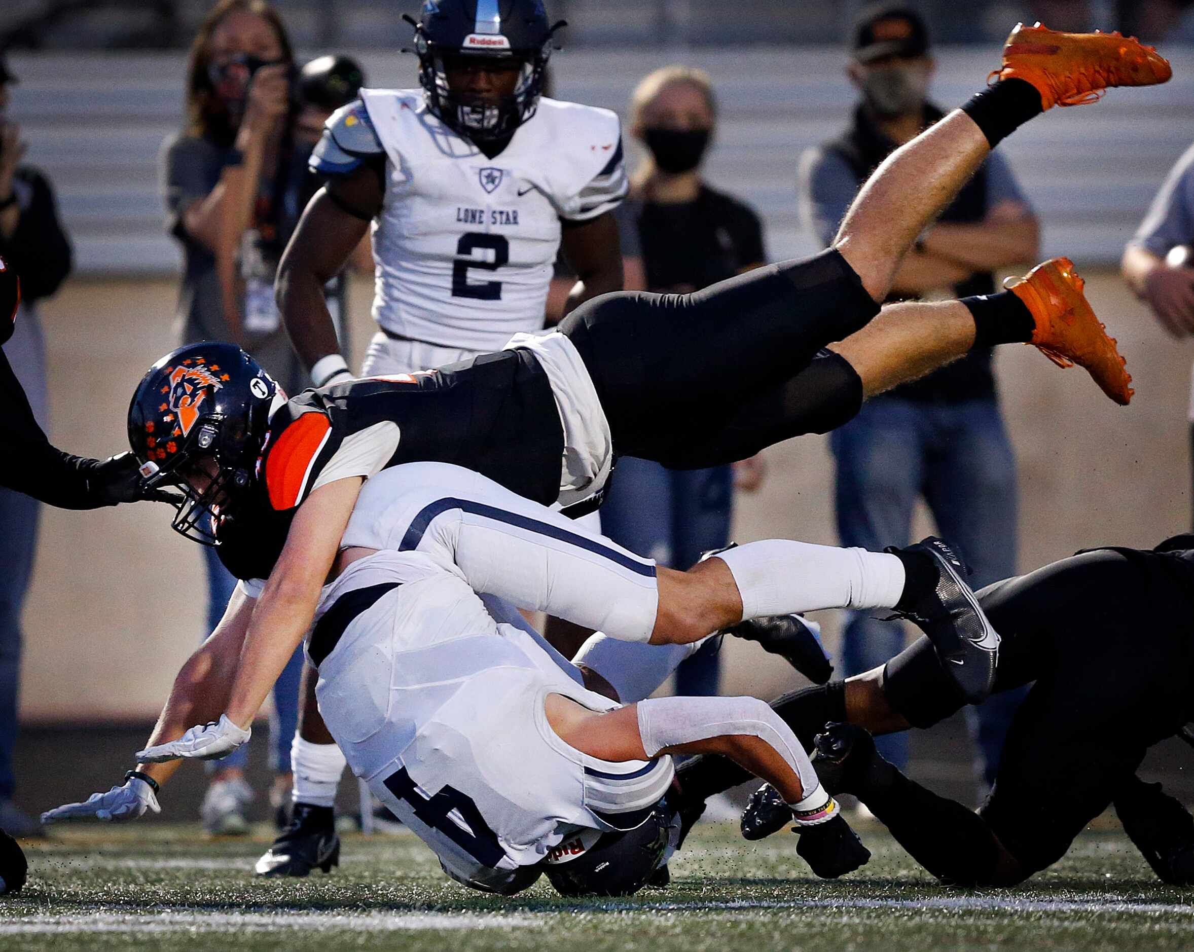 Frisco Lone Star receiver Trace Bruckler (4) is rolled up by Aledo linebacker Keenan Hess...