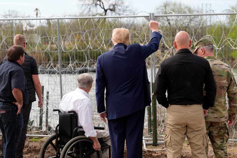Republican presidential candidate Donald Trump gestures to people across the Rio Grande in...