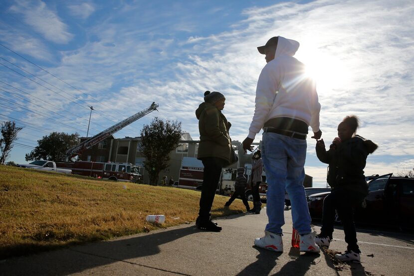 Linda Smith (from left), Courtney Turner and Jasmine Dixon wait to leave their complex...