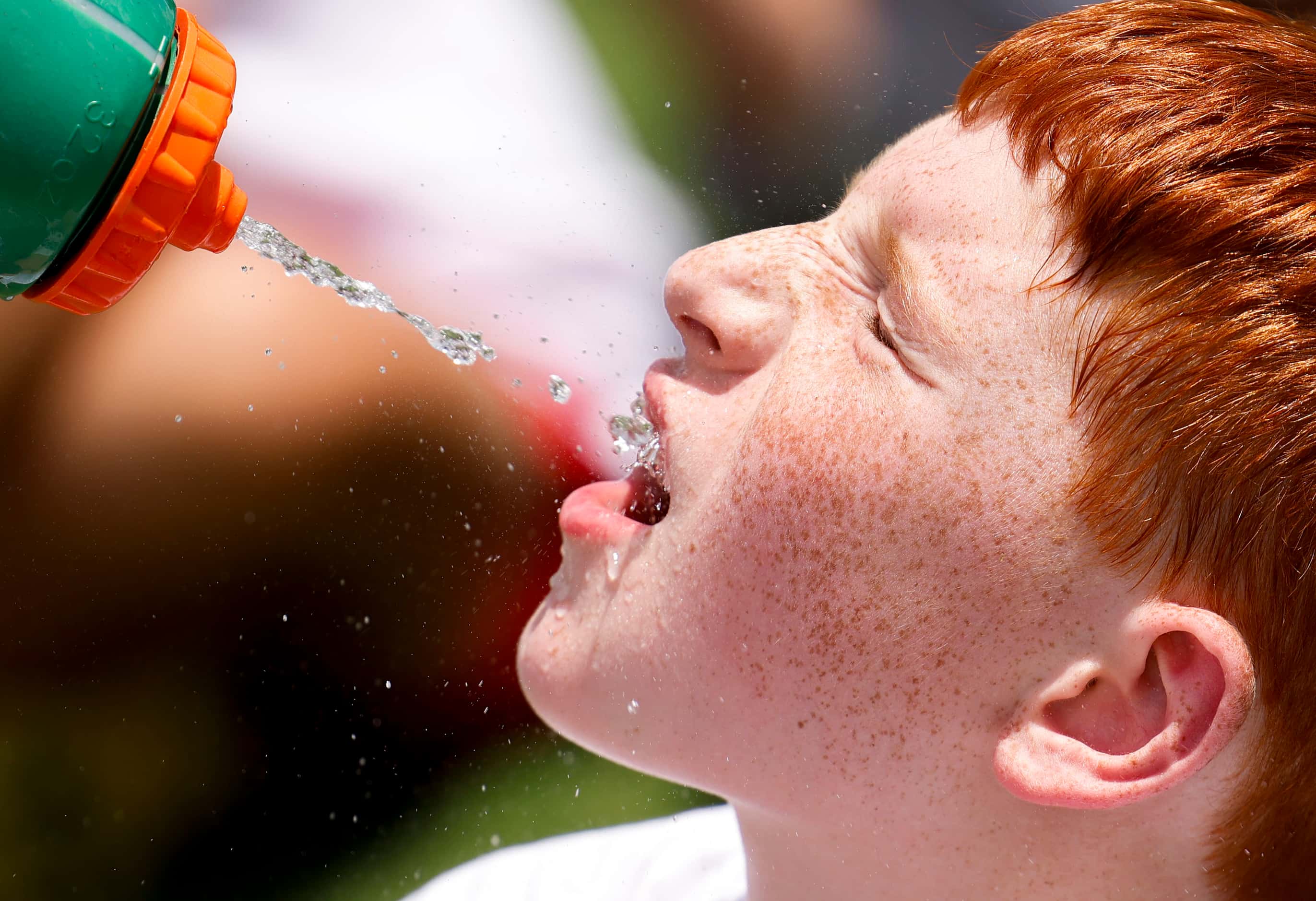 Matthew Klaassen, 9, gets a sip of water while waiting on a line to practice and interact...