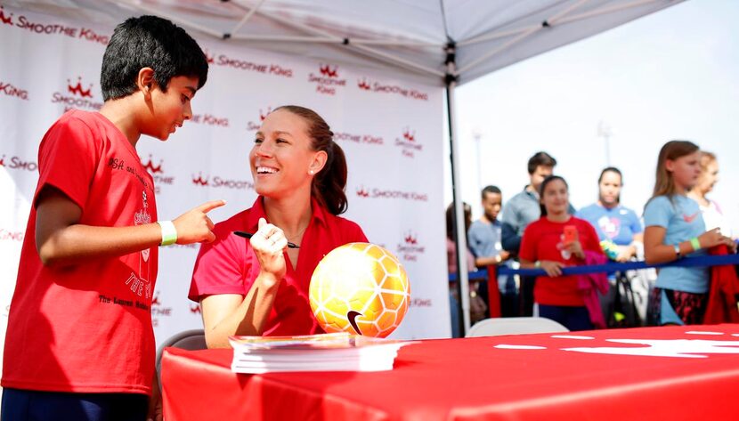 
Lauren Holiday signs a soccer ball for Jay Mokkapati, 9. She’s won two Olympic golds, and...