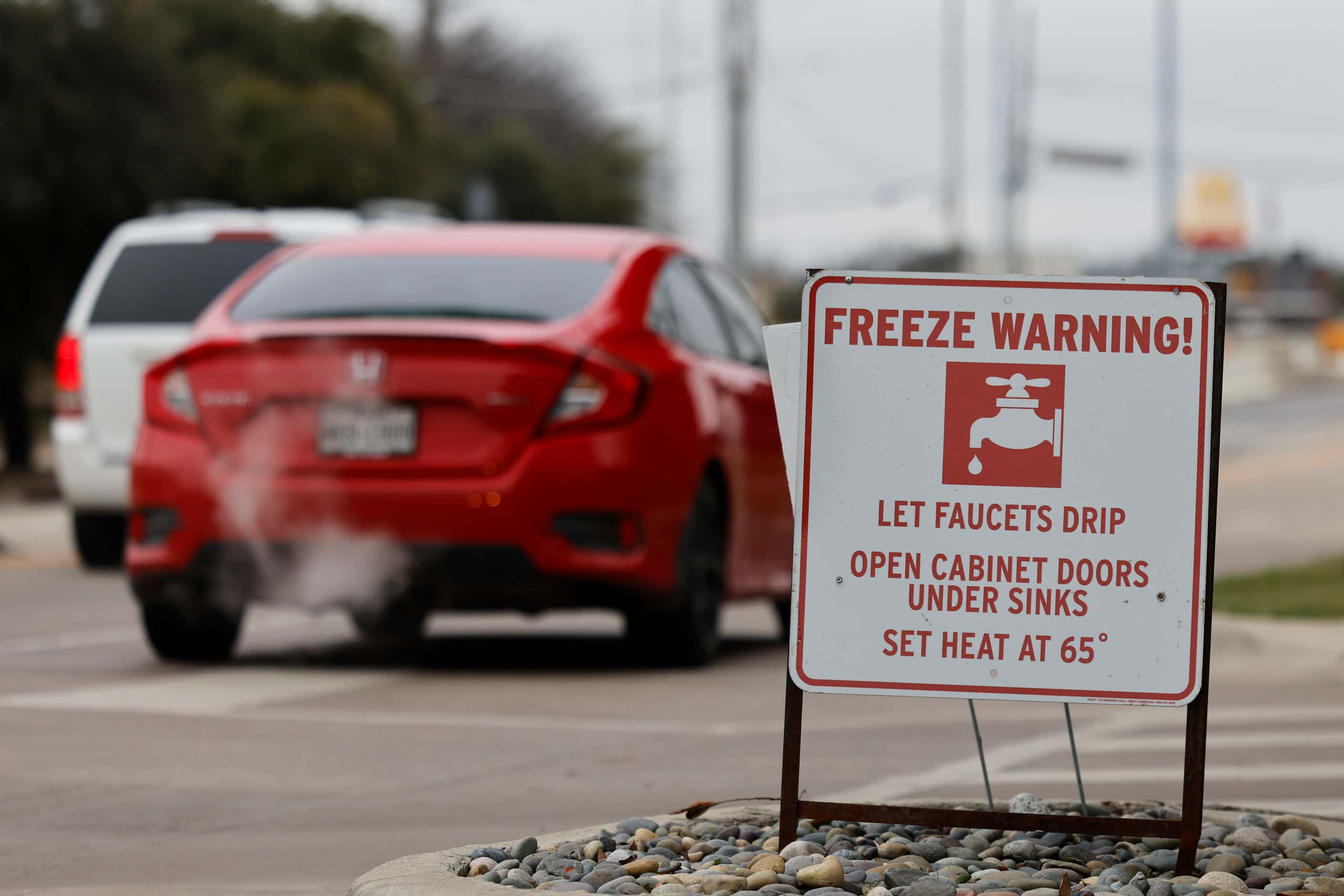 Traffic passes along freeze warning cautionary sign as an arctic blast brought sub-freezing...