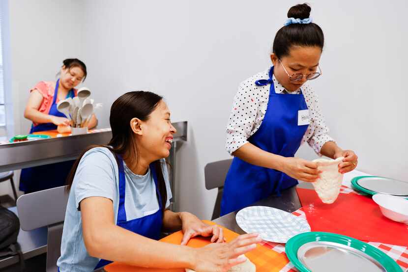 Lal Siam (left) and Hning Htang shape dough to make pizzas in a cooking class at HHM Health....