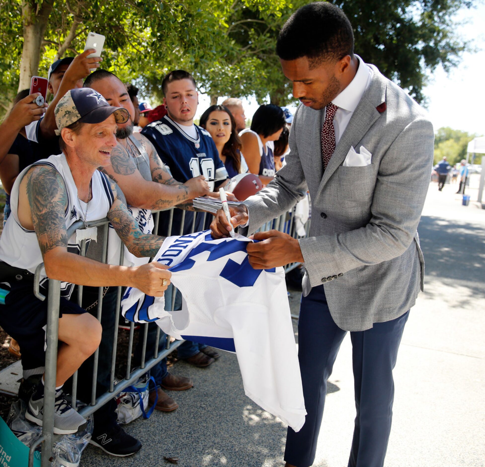 Dallas Cowboys cornerback Byron Jones signs autographs for fans a he arrives at AT&T Stadium...