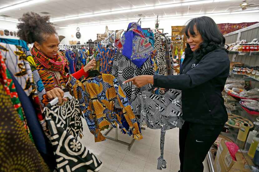 Owner Akwete Tyehimba, left, shows her regular customer Nia Khepera some dresses at...