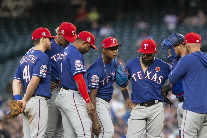 SEATTLE, WA - MAY 27:  Jose Leclerc #25 of the Texas Rangers, center, grabs at his right leg...