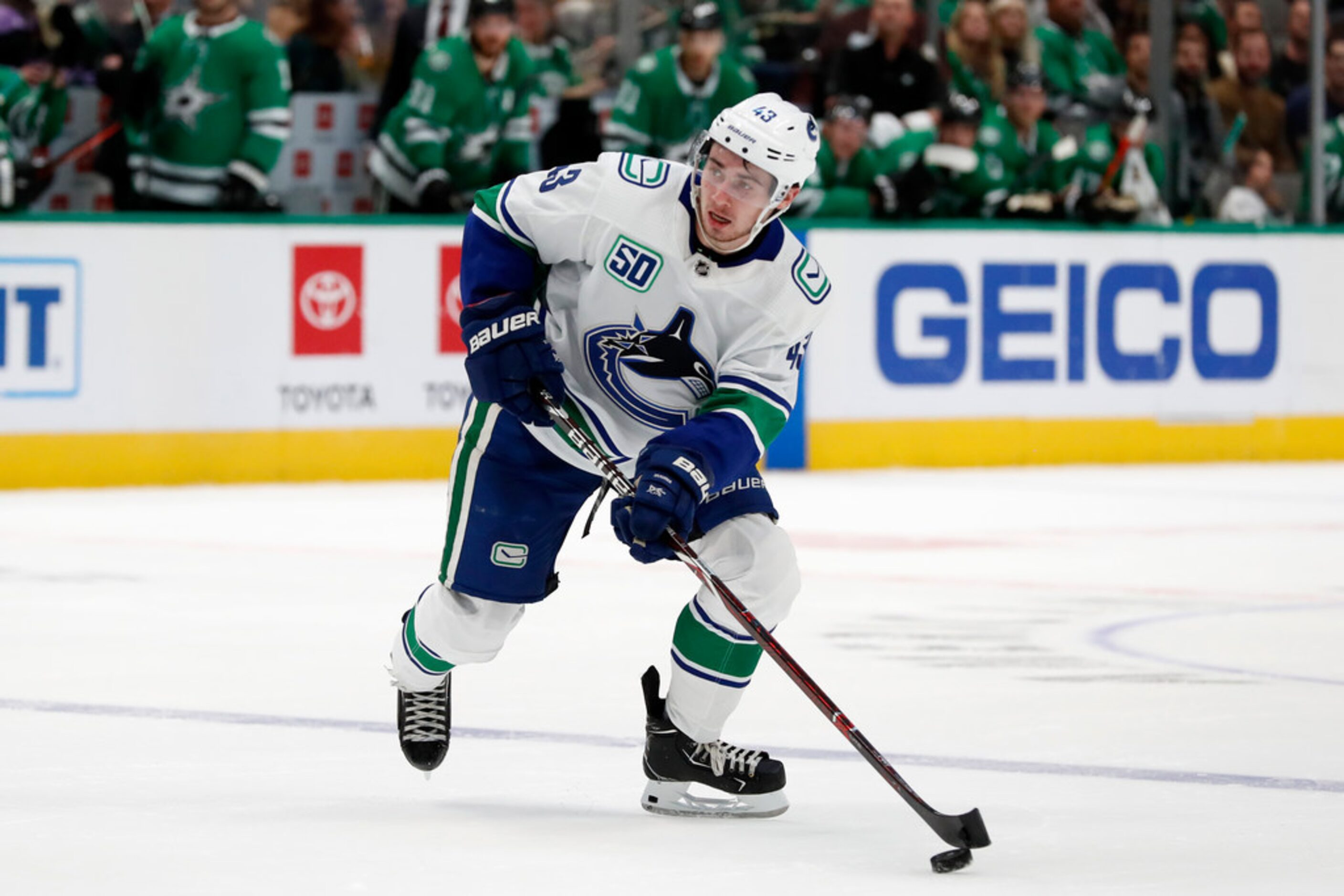 Vancouver Canucks defenseman Quinn Hughes (43) controls the puck in the second period of an...