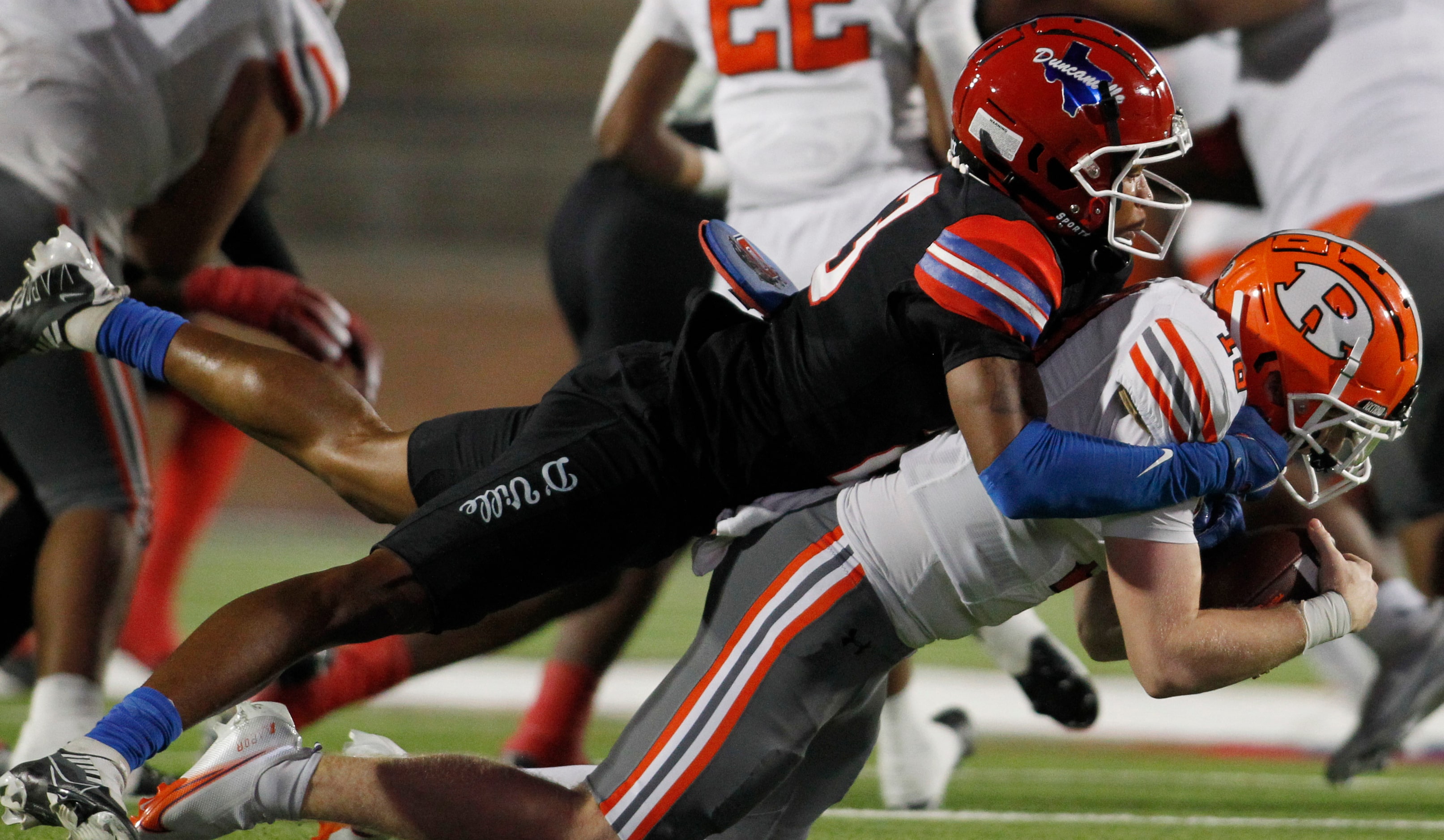 Duncanville defensive end Tamir Hunt (23) top, registers a quarterback sack of Rockwall...