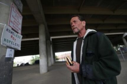  Ron McDowell ate a burger next to a "No Trespassing" sign at Tent City after city work...