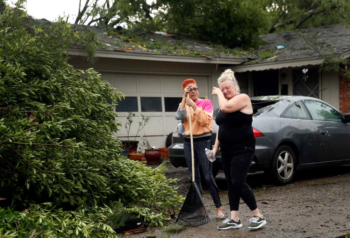 Resident Peggy Pierson (right) wipes away tears as she and her roommate Penny Ruiz cleanup...