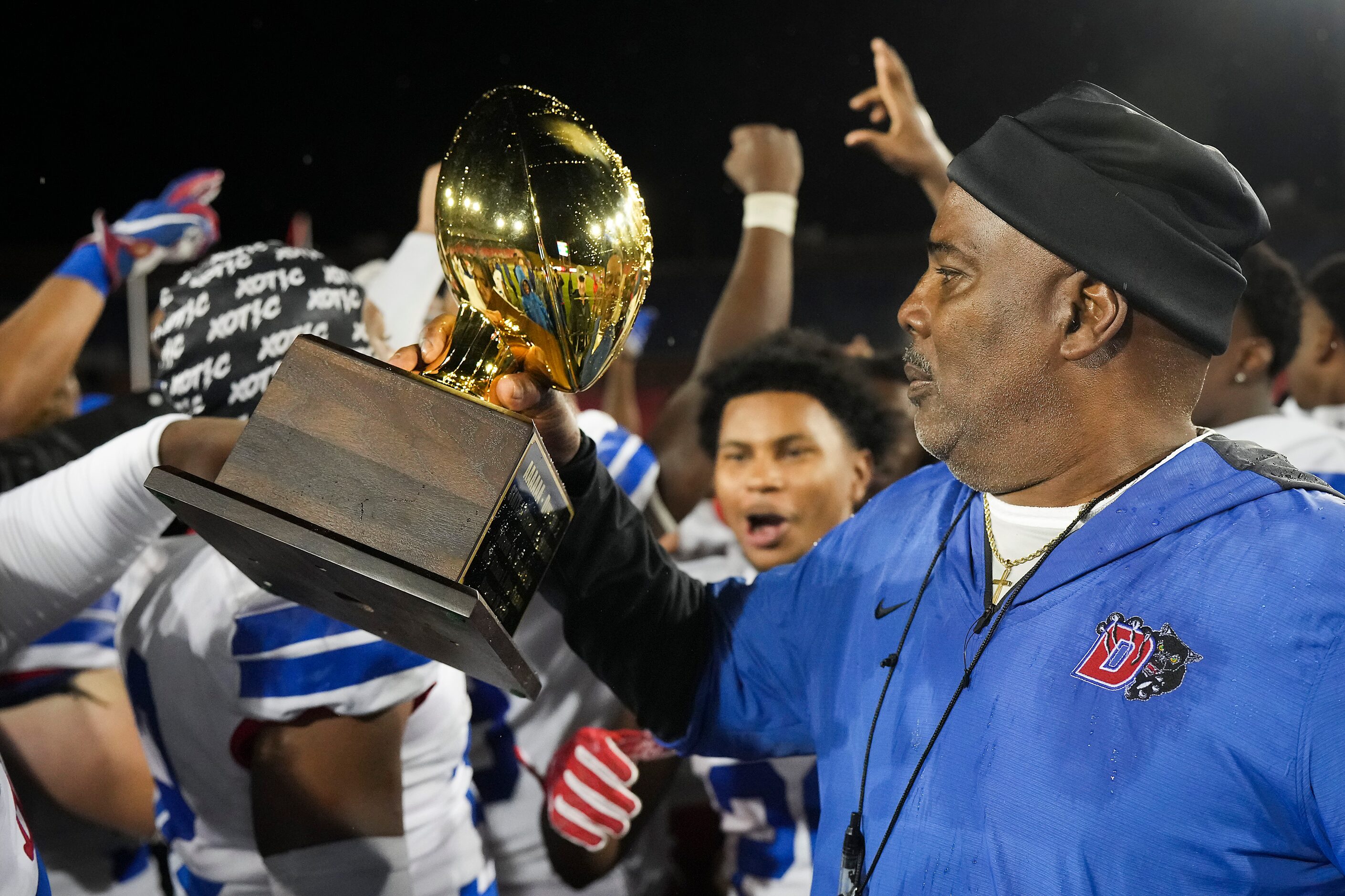 Duncanville head coach Reginald Samples lifts the game trophy after a victory over Prosper...