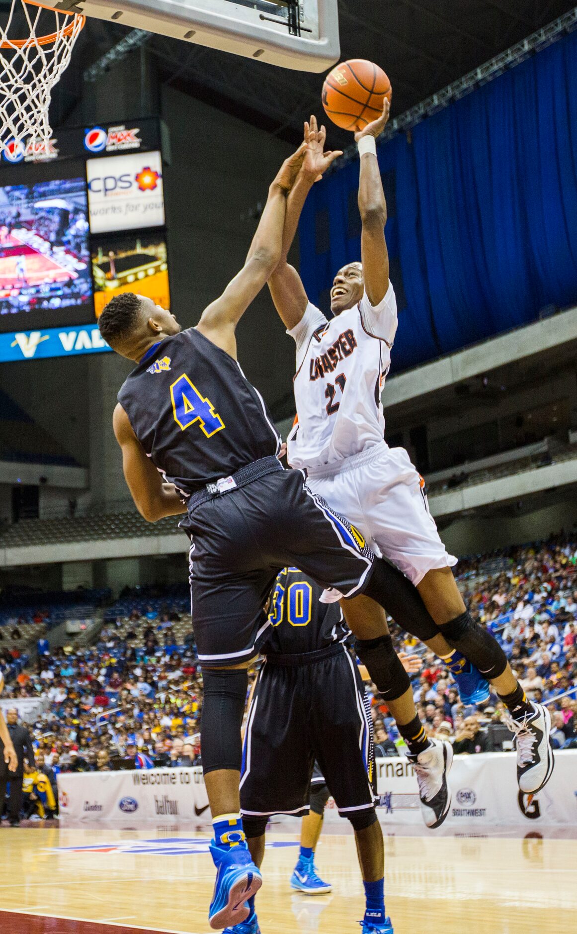 Lancaster guard/forward Brandon Moore (21) goes up for a shot over Beaumont Ozen forward...