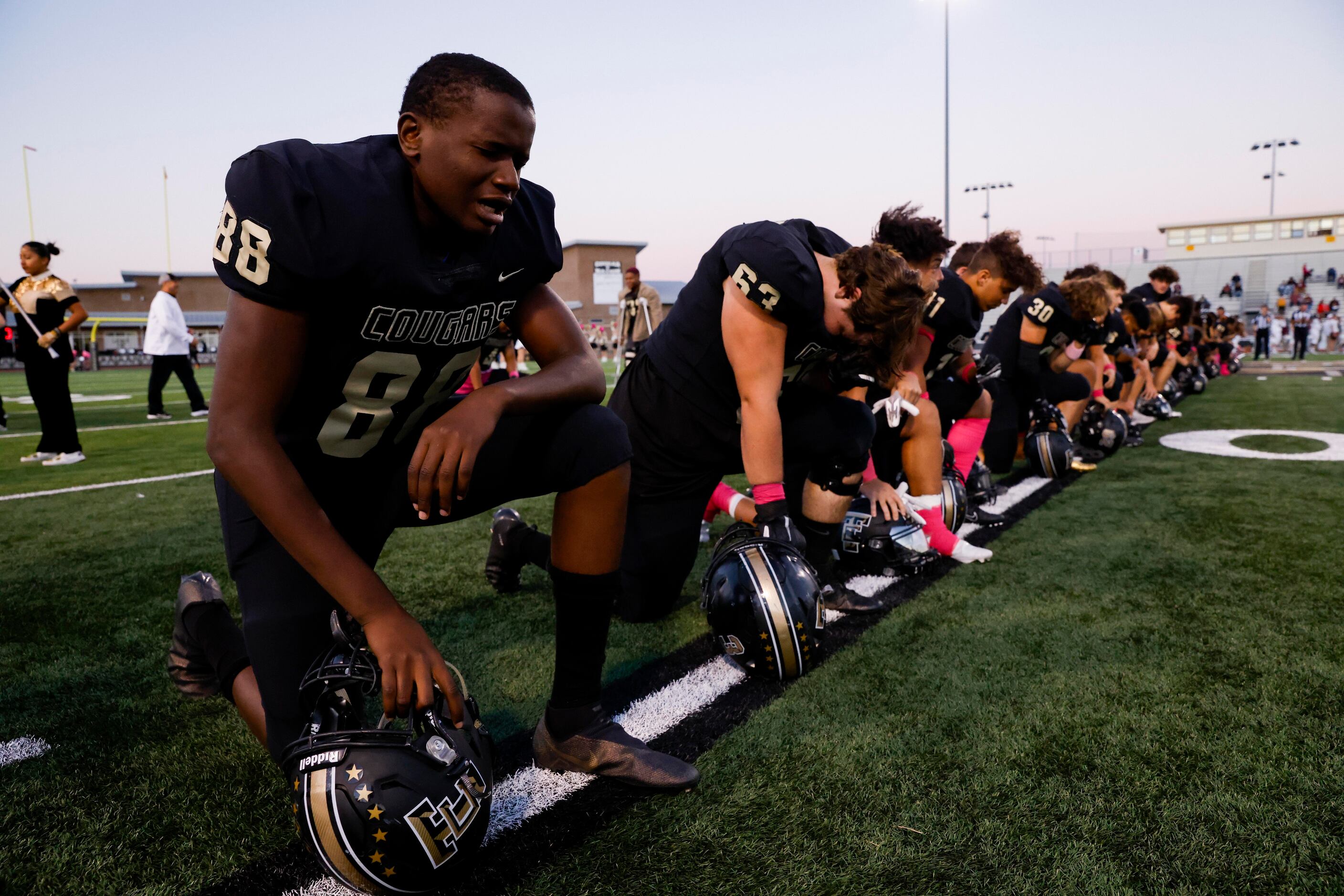 The Colony High School kneel before the start of a District 5-5A Division I game between...