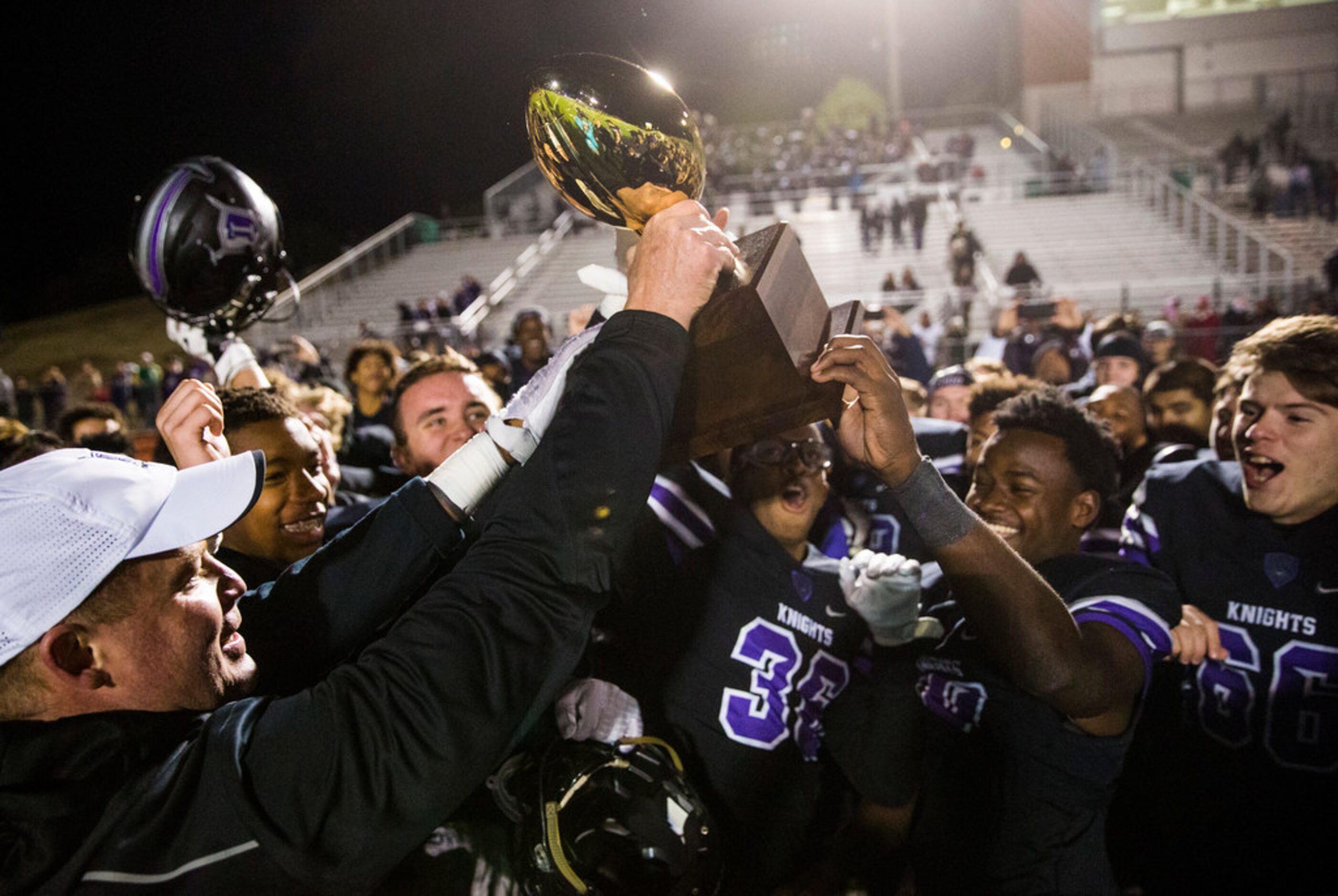 Frisco Independence football players react to receiving the bi-district championship trophy...