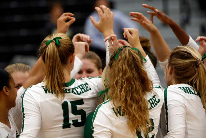 Members of the Waxahachie varsity volleyball team prepare to break from a timeout during a...