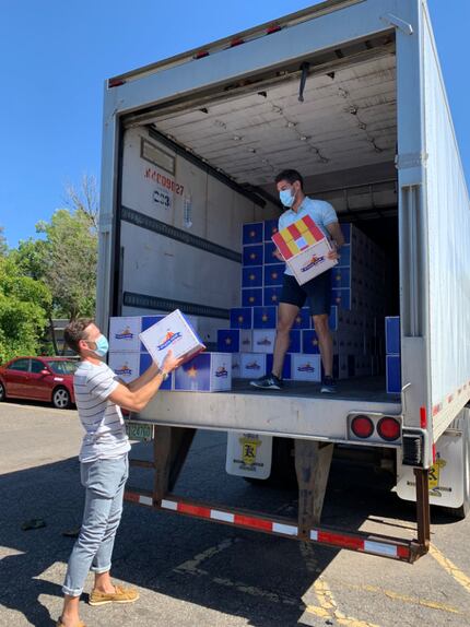 Josh Zamansky, right, founder and CEO of StateFairToGo.com, unloads boxes with Joel McComas,...