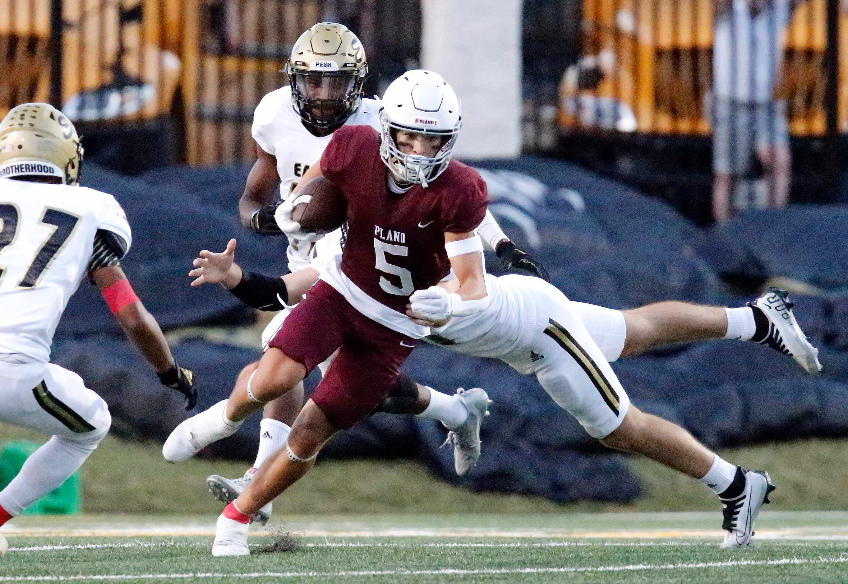 Plano Senior High School wide receiver Anthony Howard (5) is slowed down by Plano East High...