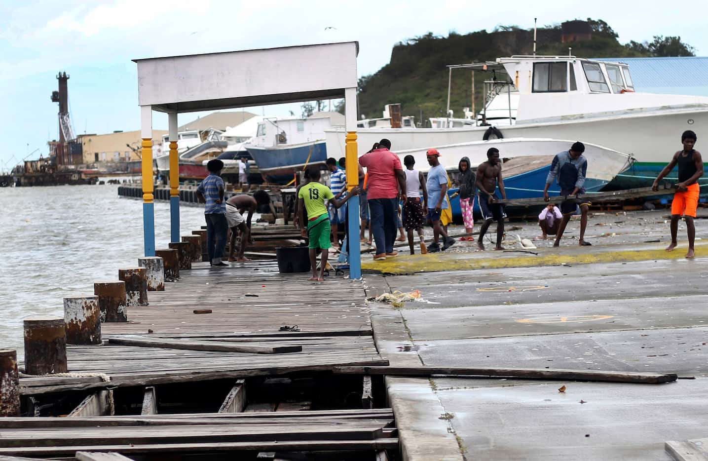 People recover broken parts of the dock after the passing of Hurricane Irma, in St. John's,...
