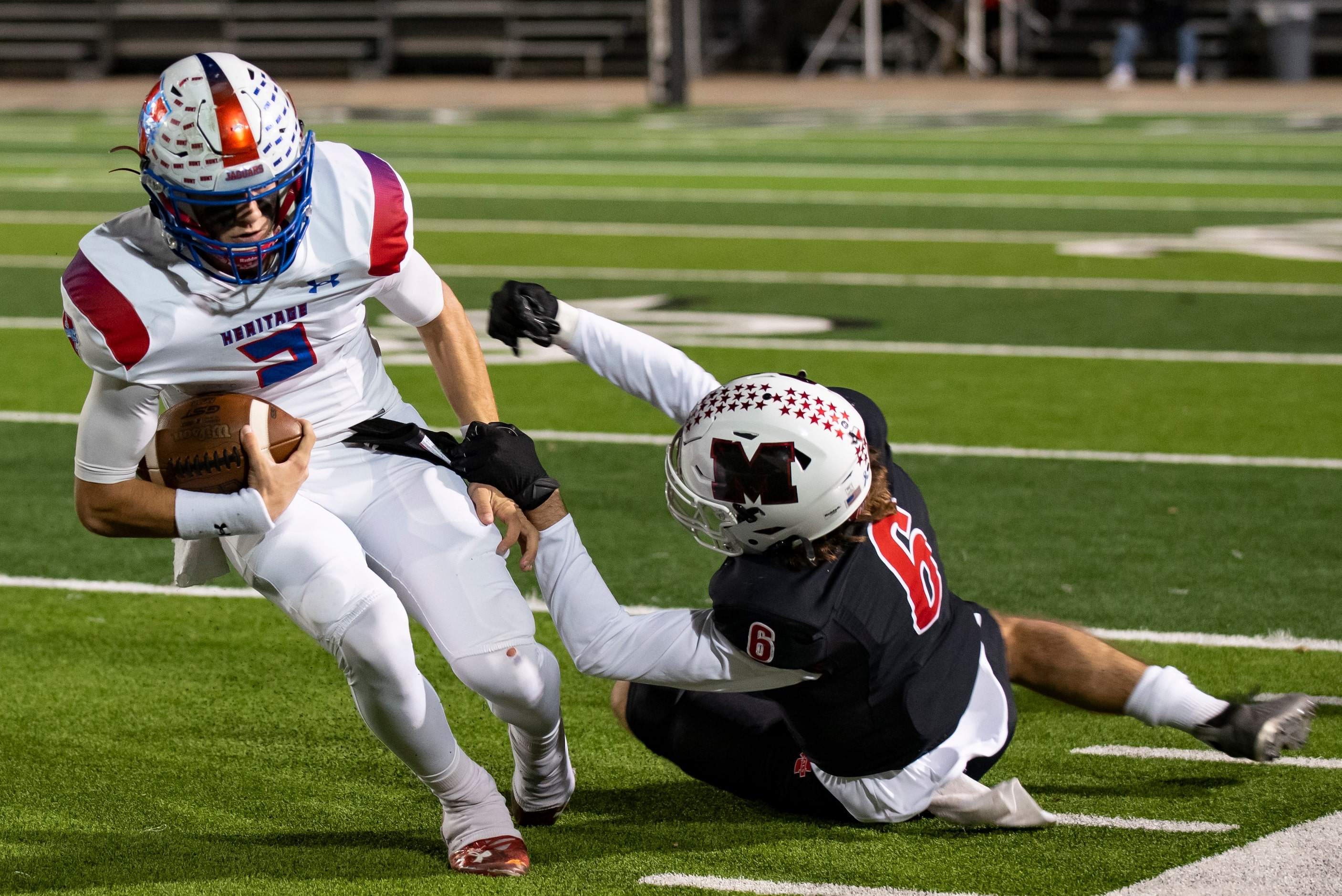 Midlothian Heritage junior Kaden Brown (2) is dragged down by Melissa senior Ryan Johnson...