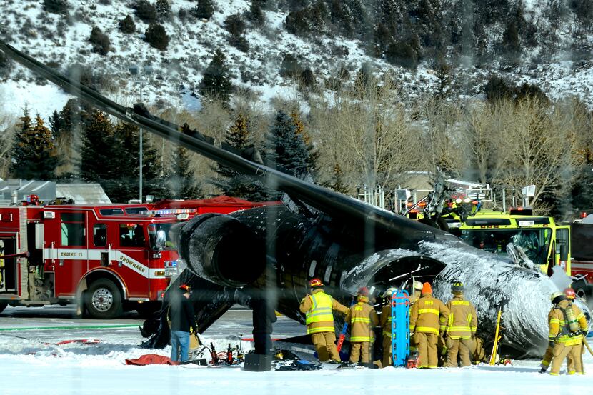 Emergency crews work near a passenger plane that crashed upon landing at the Aspen-Pitkin...