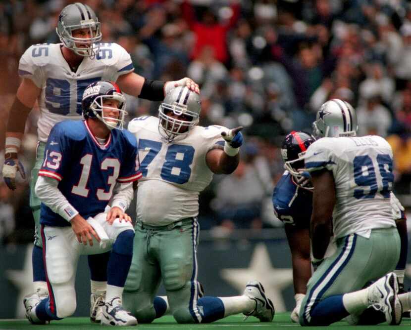 Leon Lett (78) points to Greg Ellis (right) as Giants quarterback Danny Kanell gets up after...