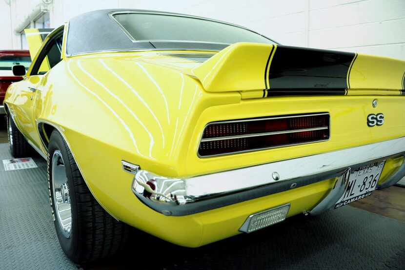 A 1969 Camaro SS, with striking black and yellow paint and black vinyl hardtop, was on...