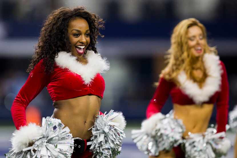 Dallas Cowboys cheerleaders perform wearing Christmas-themed costumes.