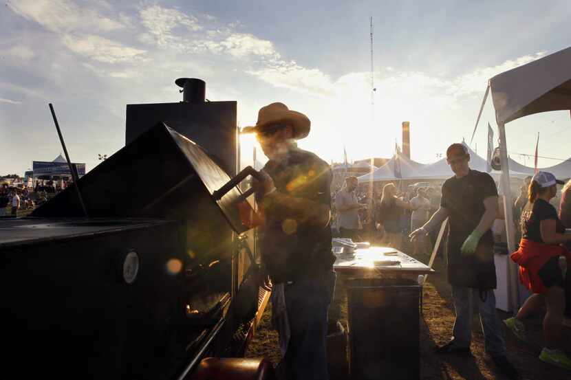 A cook checks the temperature of meat during a festival at Panther Island Pavilion in Fort...