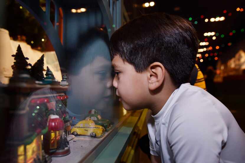 Nathan Reyna, 5, of Dallas, places his nose against glass as he watches the trains roll by...