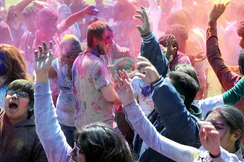Revelers celebrate Holi with colored powder.