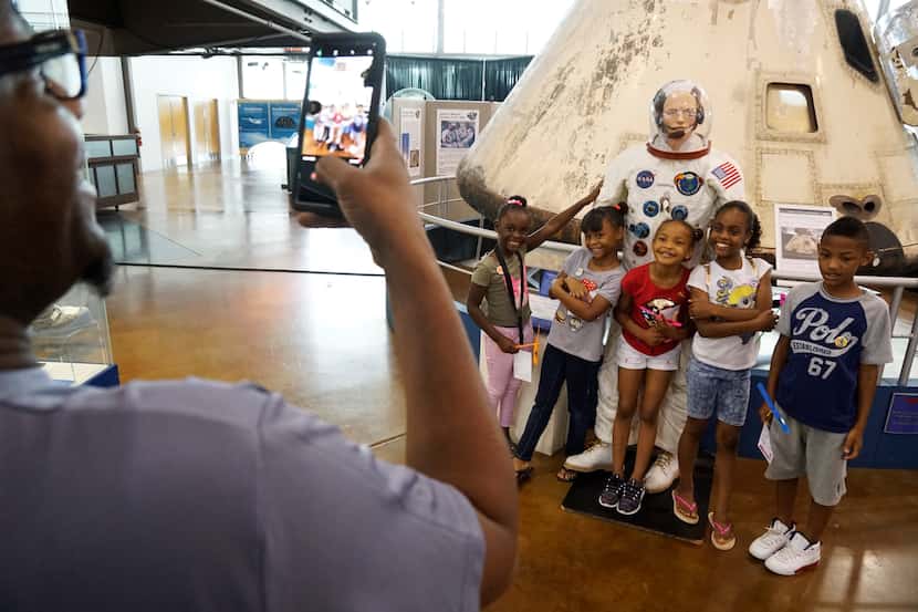 Children pose in front of a space capsule at the Frontiers of Flight Museum in Dallas.