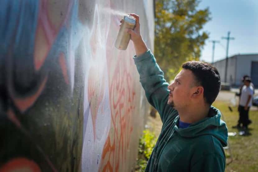Graffiti artist Irvin Botello, also know as “Serfx,” paints on the approved space on...