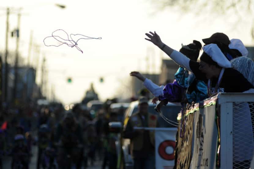 Participants launch beads out into the crowd during a Mardi Gras parade.