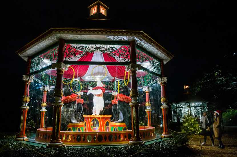 Visitors walk past the Five Golden Rings gazebo at Holiday at the Arboretum, featuring The...