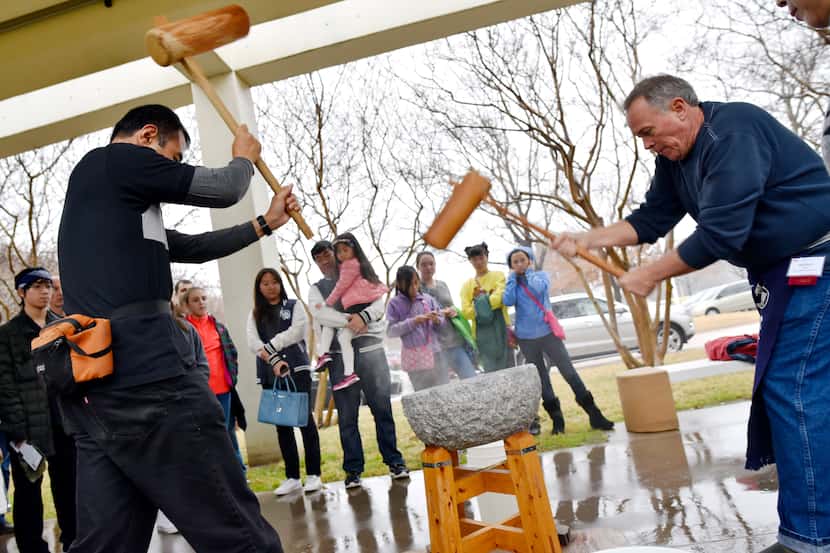 Naoki Hariyama, 46, left, and Mark Berry, 56, right, perform a rice pounding called...
