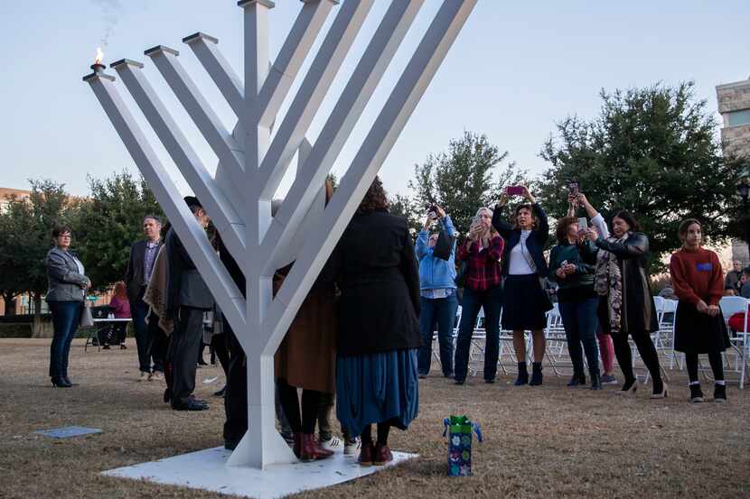 People take a photo in front of the menorah at the 2019 Chabad of Frisco menorah lighting.
