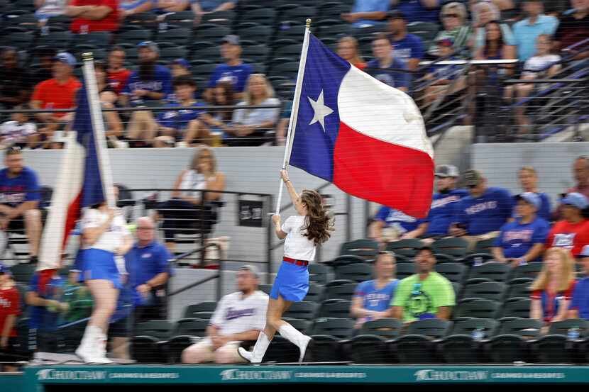 Members of the Texas Rangers Six Shooters race across the dugout at Globe Life Field.