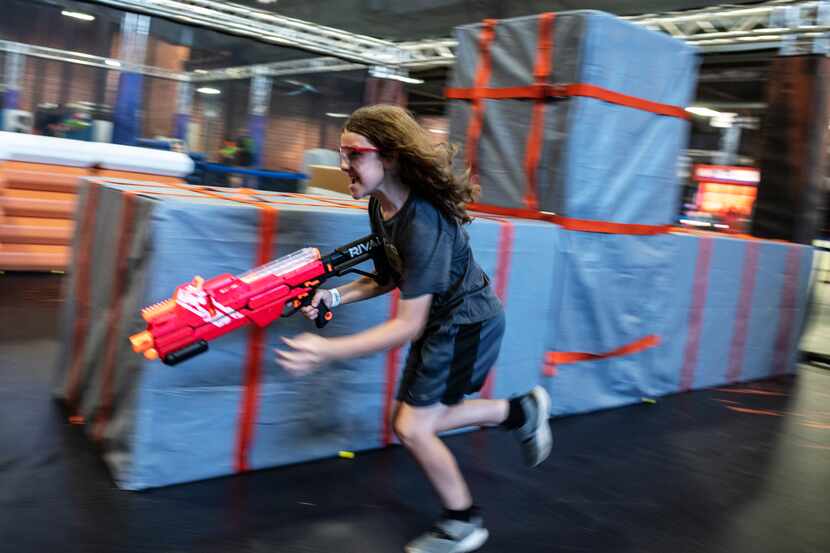 Kellen Hoss runs with his Nerf Blaster dodging Nerf rounds as he competes in the Strange...