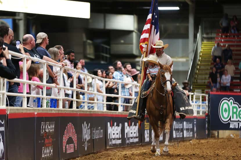 Rodeo fans stand as the American flag passes by at the Mesquite Championship Rodeo.   