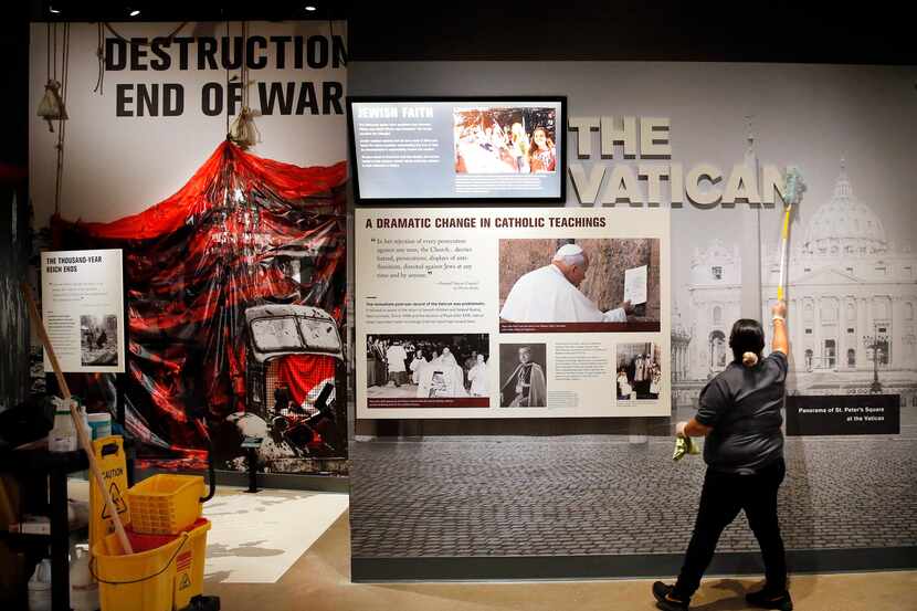 Beatriz Hernandez dusts an exhibit in the Dallas Holocaust and Human Rights Museum.