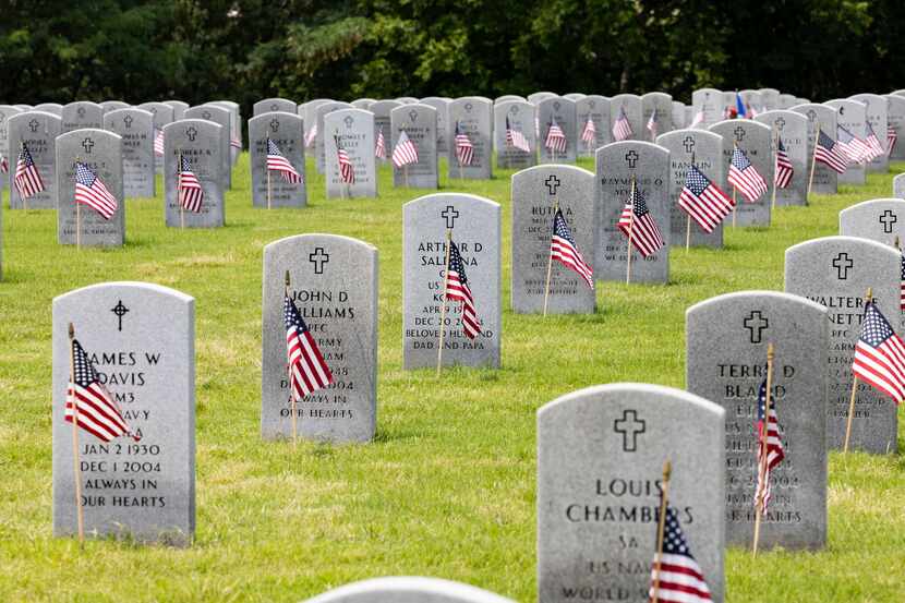 US flags sit in front of headstones at Dallas-Fort Worth National Cemetery.