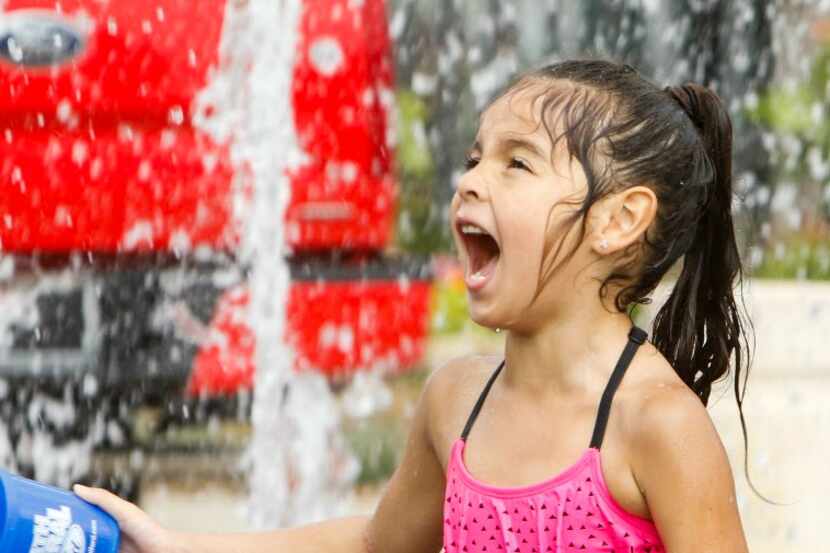 Analia Valentin runs through a fountain at at the Wildflower! Arts & Music Festival on May...