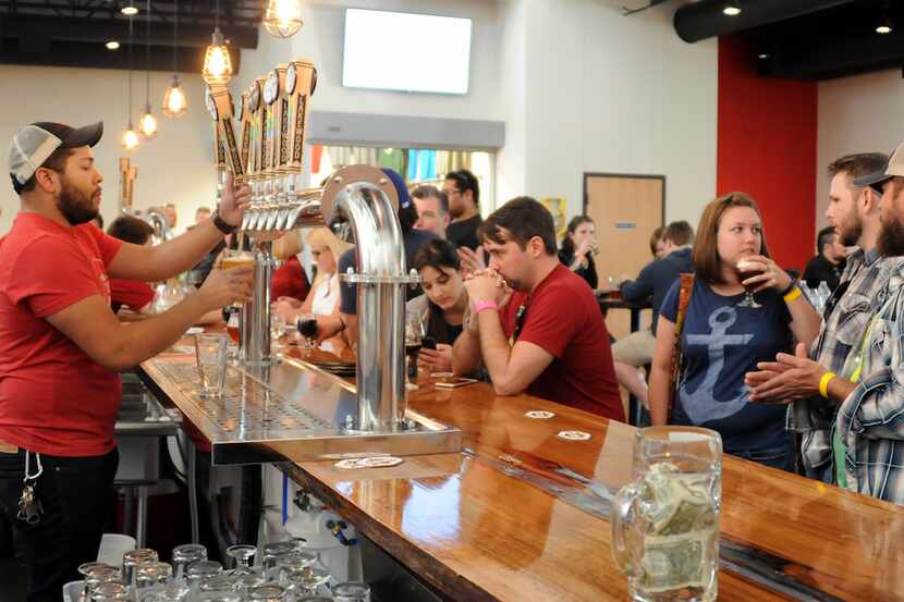 Bartender Quin Tinling serves a cold brew at Lakewood Brewing Company's grand opening of the...
