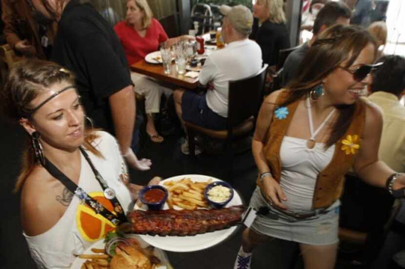 Waitresses Camie Scott, left, and Kristina Shelby work to deliver food to customers at The...