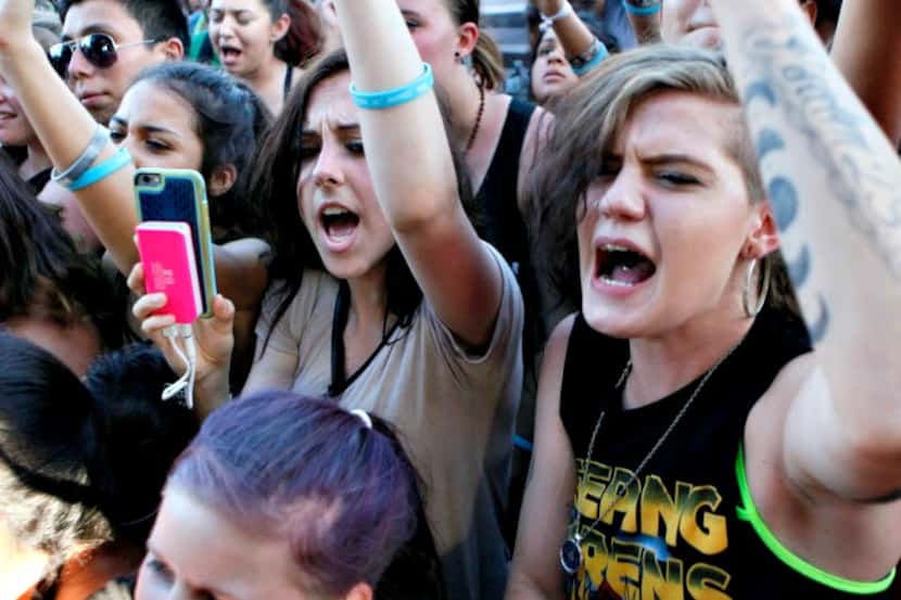 Fans react with fist pumps during the Vans Warped Tour 2016.